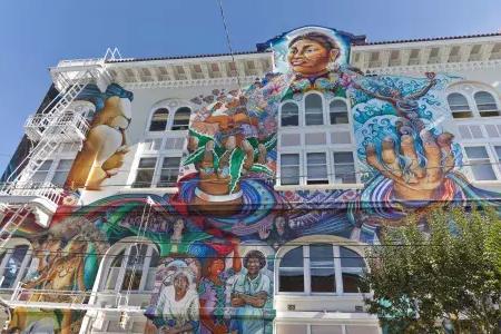 Un colorido mural a gran escala cubre el costado del Edificio de Mujeres en el Distrito de la Misión de 贝博体彩app.